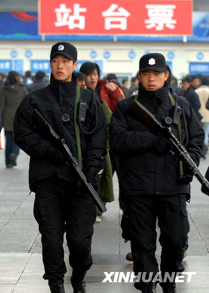 1月13日,两名特警在北京西站广场执勤.