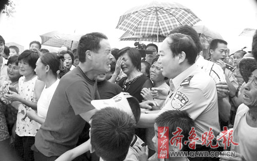 右图:朱宝良的父亲朱庆建紧握苍山县公安局副局长宋传增的手说