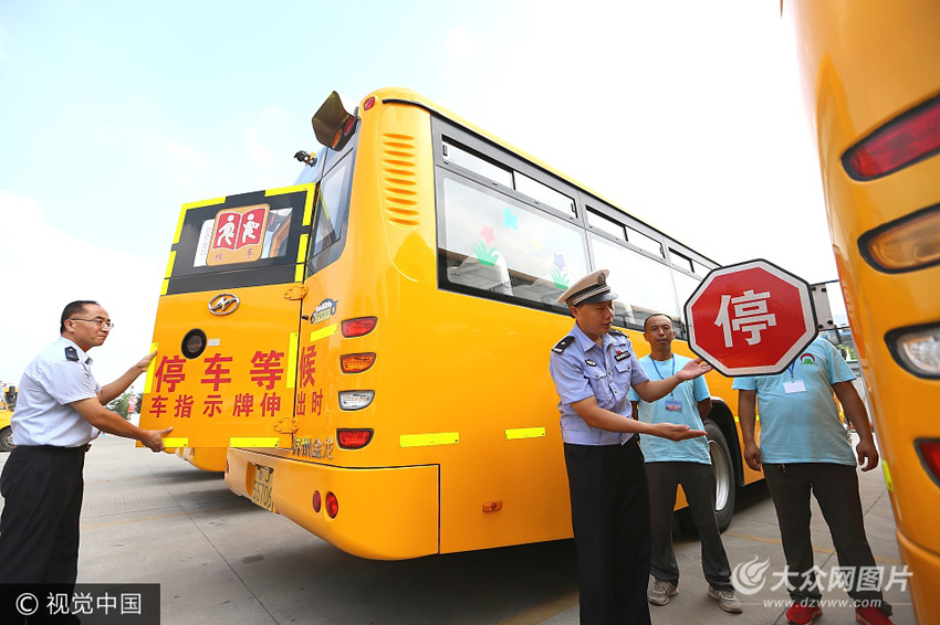 8月22日,泰安市宁阳县交警大队民警商积显(右三)和校车工作人员对停车