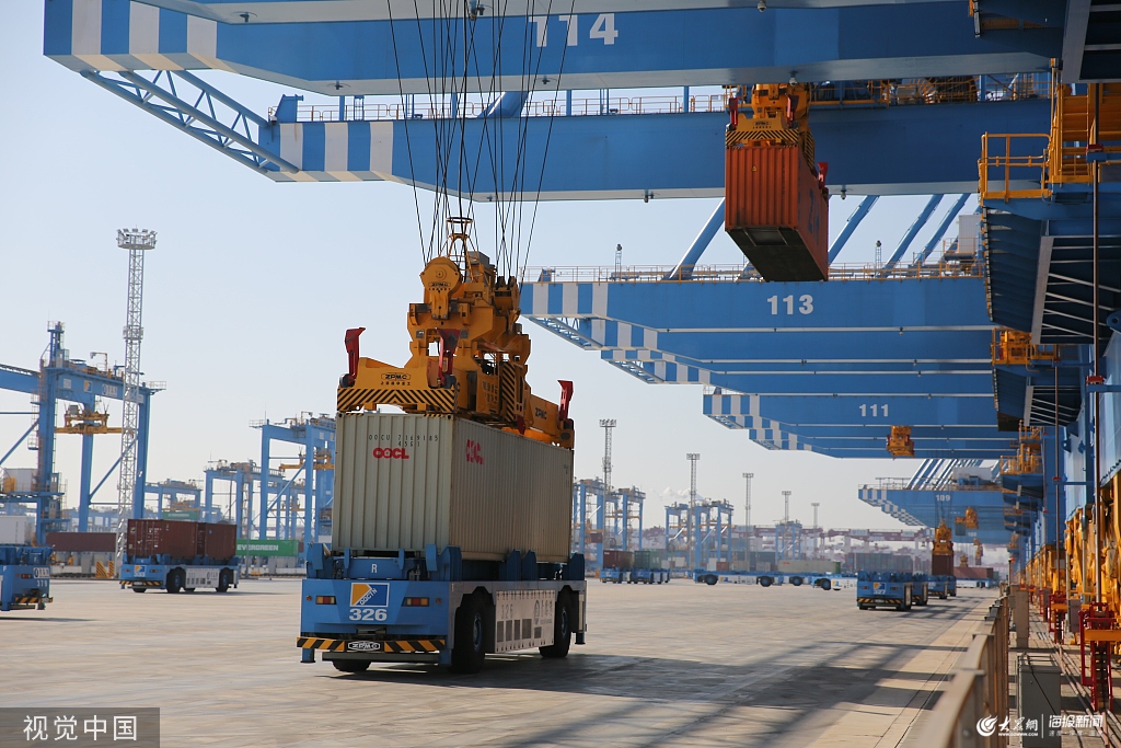 青岛港全自动化码头(二期)投产运营,一艘货轮在装卸货物