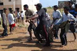 Some young men carry a body of a woman killed by tial waves in the coastal area of Chennai, capital of south Indias Tamil Nadu Dec. 26. Over a thousand people have been killed in earthquake-caused tidal waves in Tamil Nadu, Andhra Pradesh and Andamand and Nicobar Islamabd in south India, Indian Home Minister Shivraj Patil said here on Sunday. And he told reporters after a meeting of the Crisis Management group that Tamil Nadu was the "worst affected" with possibly over 800 people killed.