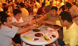 People toast with beer in the Beer Street that opened to the public in Qingdao, East Chinas Shandong Province on August 16, 2005. [sina.com]