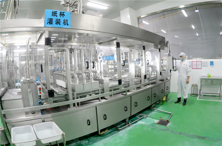 东君乳业公司工人正在全自动搅拌型酸奶灌装机生产线紧张作业