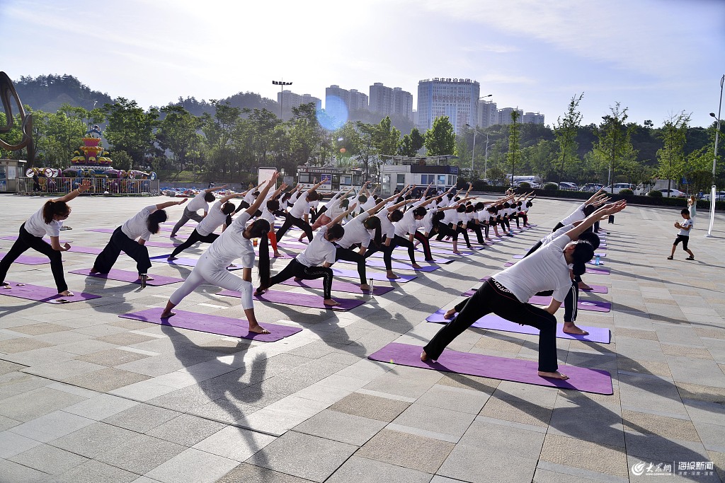 2019年7月6日,湖北十堰市户外瑜伽爱好者正在该市区某广场上训练课