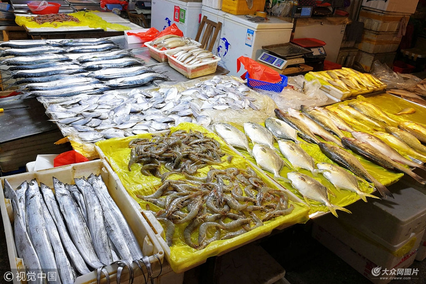 2018年5月14日,山东青岛一海鲜市场,摊位上摆放丰富的新鲜海鲜
