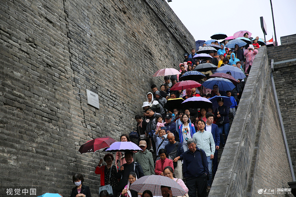 西安城墙变人墙 游客雨天撑伞登城墙观人海